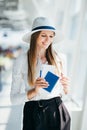 Close-up, Woman holds air tickets and passports in her hands against the backdrop of empty check-in counters at the Royalty Free Stock Photo