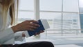 Close-up, Woman holds air tickets and passports in her hands against the backdrop of empty check-in counters at the Royalty Free Stock Photo