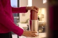 Close Up Of Woman In Kitchen Wearing Fitness Clothing Blending Fresh Ingredients For Healthy Drink