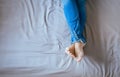 Close up of woman legs with blue jeans,Feet and stretch lazily on bed Royalty Free Stock Photo