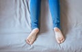 Close up of woman legs with blue jeans,Feet and stretch lazily on the bed Royalty Free Stock Photo