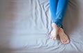 Close up of woman legs with blue jeans,Feet and stretch lazily on the bed Royalty Free Stock Photo