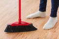 Close up of woman legs with broom sweeping floor Royalty Free Stock Photo