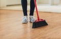 Close up of woman legs with broom sweeping floor