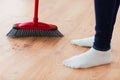Close up of woman legs with broom sweeping floor