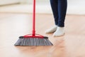 Close up of woman legs with broom sweeping floor Royalty Free Stock Photo
