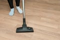 Close up of woman with legs vacuum cleaner cleaning floor at home Royalty Free Stock Photo