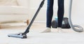 Close up of woman legs with vacuum cleaner at home Royalty Free Stock Photo