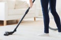 Close up of woman legs with vacuum cleaner at home Royalty Free Stock Photo