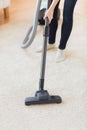 Close up of woman legs with vacuum cleaner at home Royalty Free Stock Photo