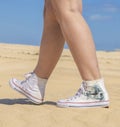 Close up of woman legs wearing a pair of red sneakers, isolated on white