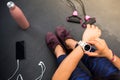 Close up woman looking at her smartwatch during doing exercise at home. People with wearables doing fitness