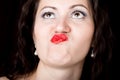Close-up woman looks straight into the camera on a black background. expresses different emotions, sending a kiss Royalty Free Stock Photo