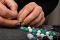 Woman making homemade beaded bracelet, closeup