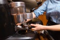 Close up of woman making coffee by machine at cafe