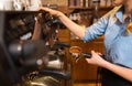 Close up of woman making coffee by machine at cafe