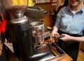 Close up of woman making coffee by machine at cafe