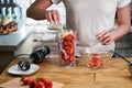 Close up of woman making strawberry smoothie. Healthy eating, cooking and summer refreshment concepts