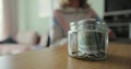 Close up woman and man takes dollars from the piggy bank. Glass jar with cash. The cash in the piggy bank. Family saving Royalty Free Stock Photo