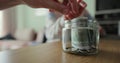 Close up woman and man takes dollars from the piggy bank. Glass jar with cash. The cash in the piggy bank. Family saving Royalty Free Stock Photo