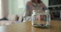 Close up woman and man takes dollars from the piggy bank. Glass jar with cash. The cash in the piggy bank. Family saving Royalty Free Stock Photo