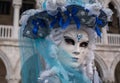 Close up portrait of woman in beautiful blue and white costume, hat and mask at the Doges Palace, Venice, during the carnival