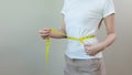 close up woman measures her waist size with tape measure. Royalty Free Stock Photo