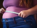 Close up of woman measuring her waist size with tape measure. Overweight concept Royalty Free Stock Photo