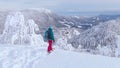 CLOSE UP: Woman observes the stunning winter landscape before snowboarding.