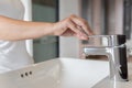 Close up Woman open chrome faucet washbasin to washing hands rubbing with soap for corona virus at water tap. Faucet and water Royalty Free Stock Photo