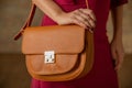 Close up woman with orange bag in hand. autumn outfit Royalty Free Stock Photo