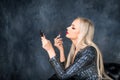 Close-up of a woman painting her lips with red lipstick. The girl does her makeup. Blonde is going to a party Royalty Free Stock Photo