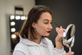 close-up of a woman paints her eyebrow with paint with a bone to a small make-up mirror. Royalty Free Stock Photo