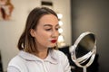 close-up of a woman paints her eyebrow with paint with a bone to a small make-up mirror. Royalty Free Stock Photo