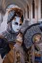 Woman poses in ornate, detailed costume, mask and hat, at the Doges Palace, St Mark`s Square during during Venice Carnival, Italy Royalty Free Stock Photo