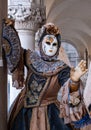 Woman poses in ornate, detailed costume, mask and hat, at the Doges Palace, St Mark`s Square during during Venice Carnival, Italy Royalty Free Stock Photo