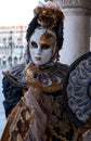 Woman poses in ornate, detailed costume, mask and hat, at the Doges Palace, St Mark`s Square during during Venice Carnival, Italy Royalty Free Stock Photo