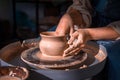 Close-up A woman potter in beautifully sculpts a deep bowl of brown clay and cuts off excess clay on a potter& x27;s wheel in