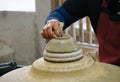 Close-up of a woman potter making smooth surface at base of a bo