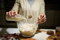 Close-up woman pouring plant based milk into a bowl with flour, for preparing dough for Christmas gingerbread cookies