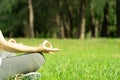 Close up woman practices yoga and meditates outdoor sitting in lotus pose on grass in the park. Healthy lifestyle outdoor. Yoga Royalty Free Stock Photo