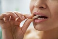 Close-up, woman puts a multivitamin pill in her mouth