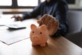 Close up woman putting coin into pink piggy bank Royalty Free Stock Photo