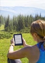 Close-up of woman reading e-book in nature Royalty Free Stock Photo