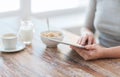 Close up of woman reading news from tablet pc