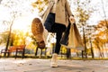 Close-up of a woman`s autumnal shoes, walking, a woman holding shopping bags on the street, in the park Royalty Free Stock Photo