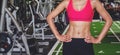 Close-up of a woman`s body bodybuilder in the gym. Portrait of muscular woman showing Strong abs on professinal gym background, Royalty Free Stock Photo