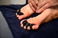 Close-up of woman`s feet receiving hot stone massage in Ayurvedic wellness spa-resort Royalty Free Stock Photo