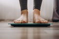 Close-up of woman`s feet weighing on scales in living room at home. Female dieting checking and weight loss. Barefoot measuring Royalty Free Stock Photo
