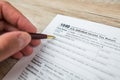 Close-up of a woman's hand filling out an empty tax form in the office